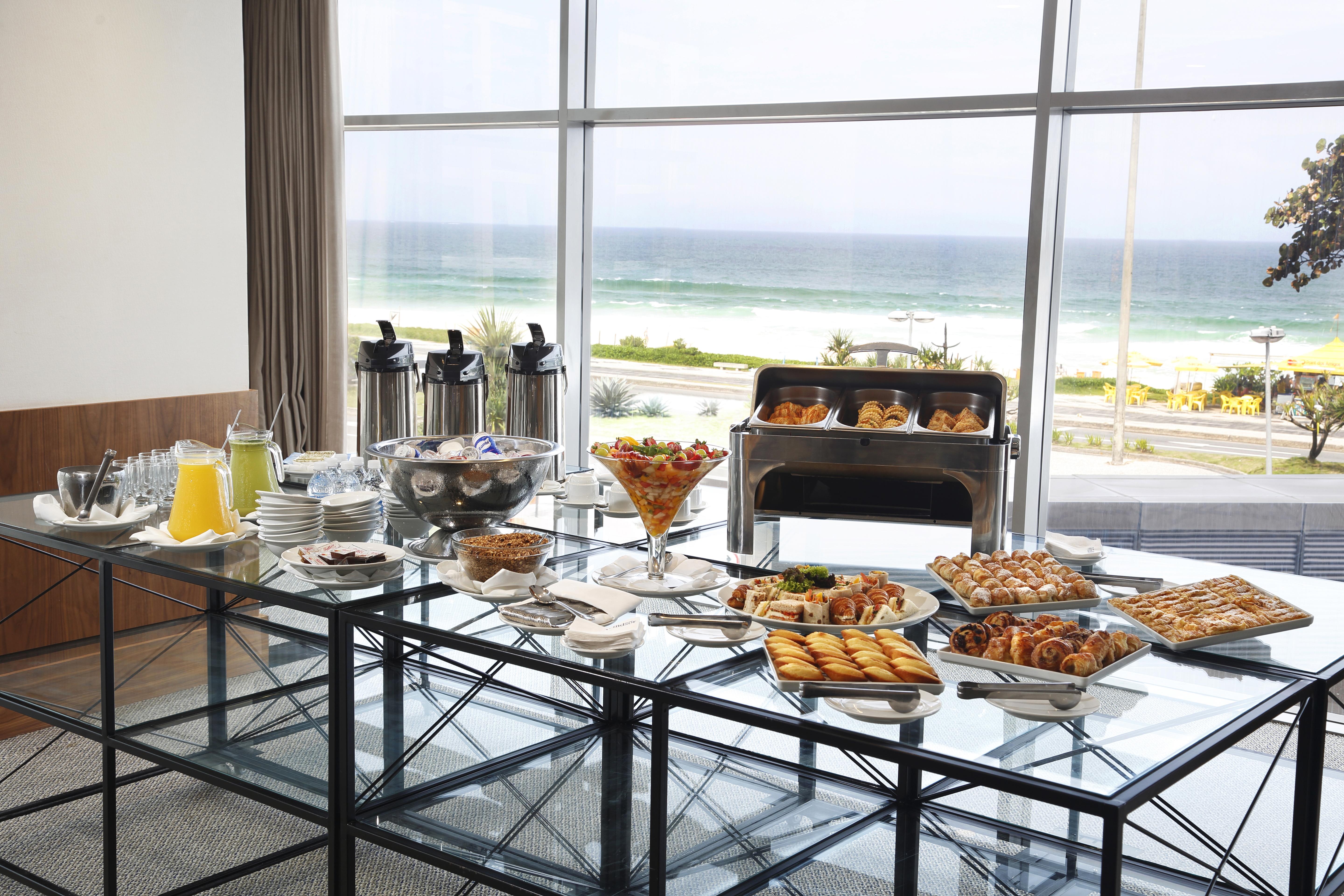 Windsor Marapendi Hotel Rio de Janeiro Eksteriør billede The photo shows a beautifully arranged buffet table with a variety of food items. In the foreground, there are multiple plates and bowls filled with different dishes, including pastries, fruits, and savory items. There are also drinks available, such